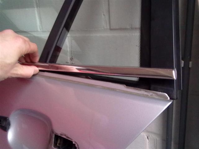 eens de sierstrip wat omhoog komt kan je stelselmatig met je vingers de strip naar boven toe trekken tot hij volledig los komt